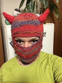 a person wearing a knitted devil hat