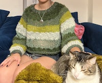a woman sitting on a couch with a cat