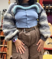 a woman wearing a sweater and pants in a shop