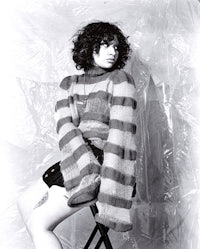 a woman in a striped sweater sitting on a chair